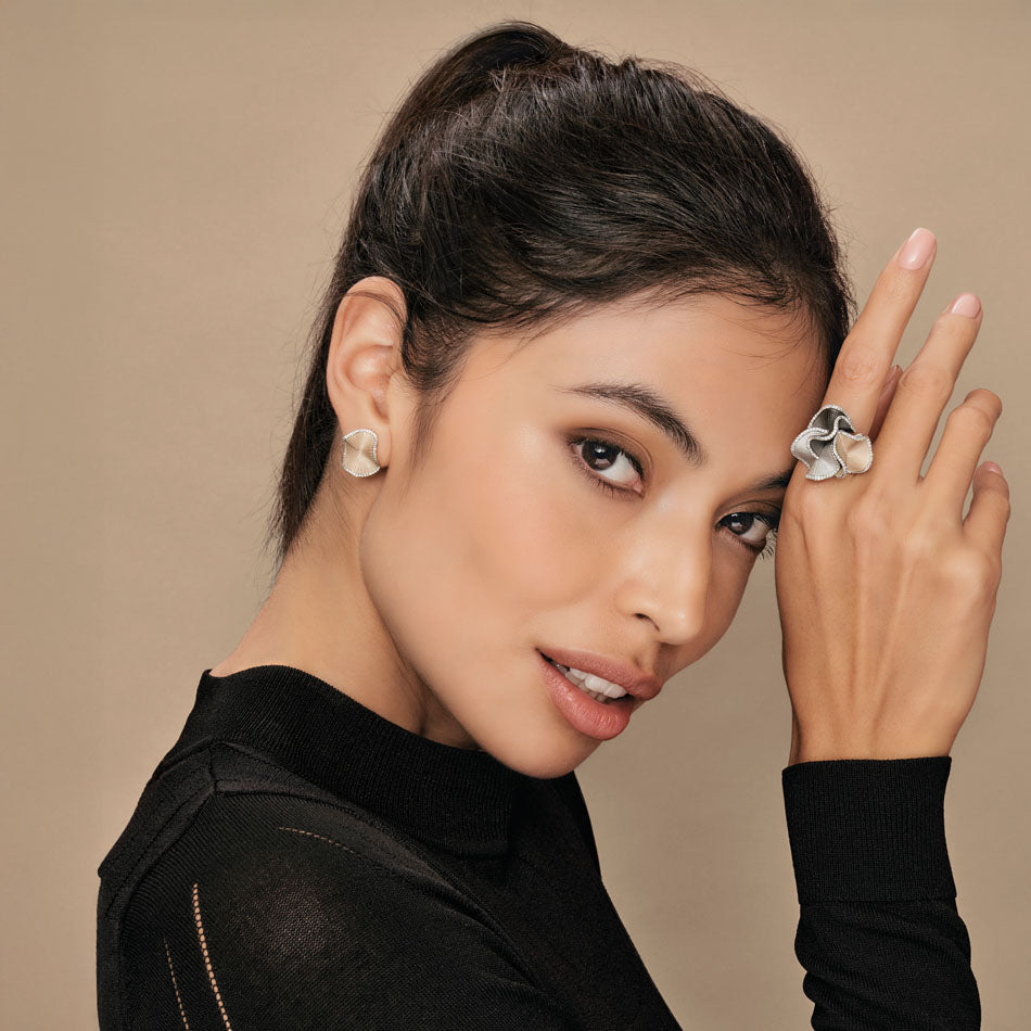 Model wearing Anna Maria Cammilli diamond earrings and matching ring, available at Lester Lampert