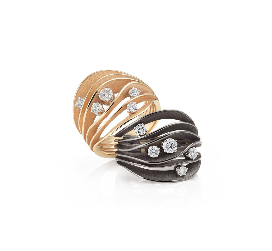 Anna Maria Cammilli yellow and black gold rings displayed on white background at Lester Lampert
