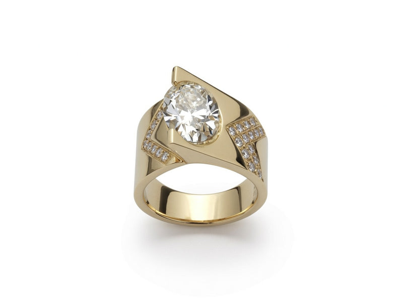 Wide gold ring with an oval diamond set at an angle and diamond accents