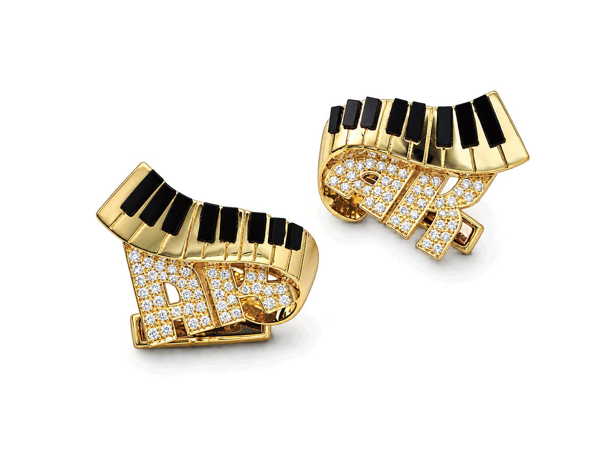 Pair of gold earrings shaped as piano keys above diamond-set initials
