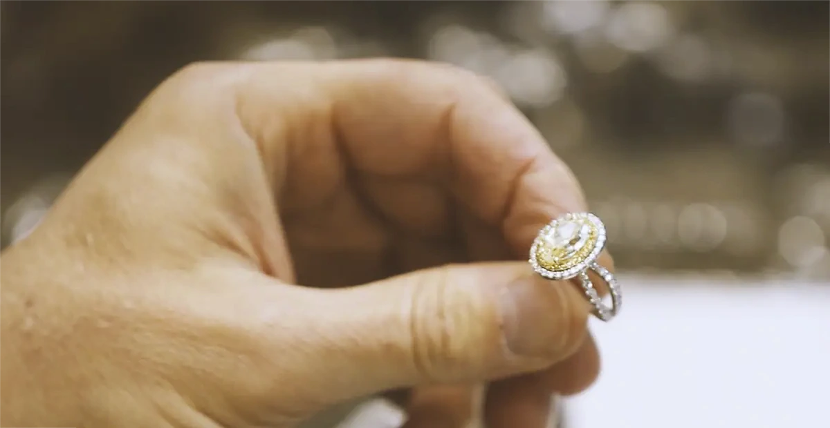 Skilled Chicago jeweler carefully holding a stunning diamond engagement ring, symbolizing precision, craftsmanship, and commitment to creating unforgettable custom jewelry moments.