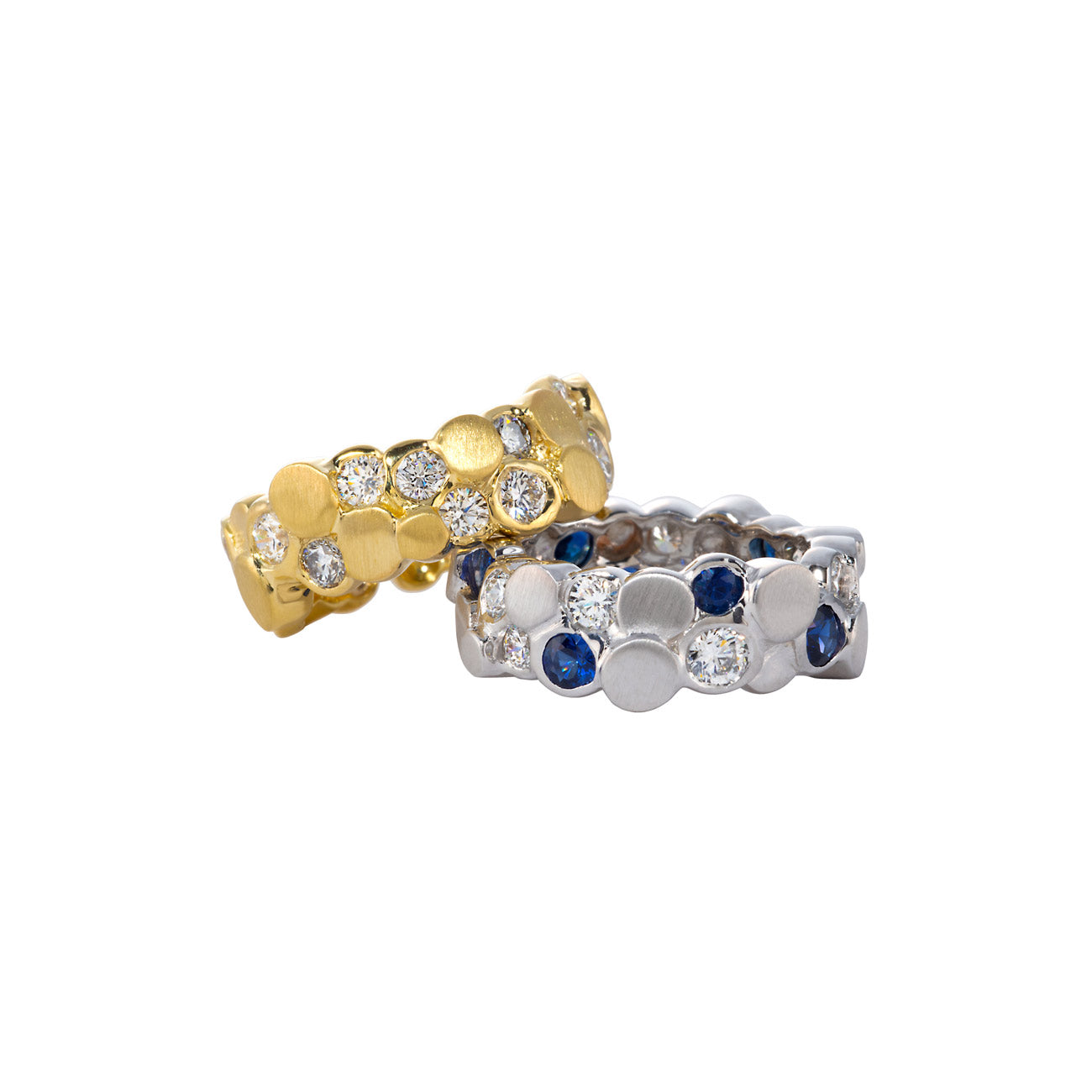 Gold and platinum bands laying together featuring diamonds and sapphires by chicago's best jeweler, Lester Lampert.