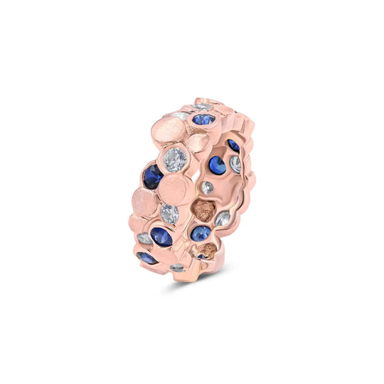 The BubbeLLes™ Ring by Lester Lampert in 18k rose gold, showcasing Ideal-cut diamonds and sapphires with contrasting bright and satin polishes, available at a Chicago jewelry store.