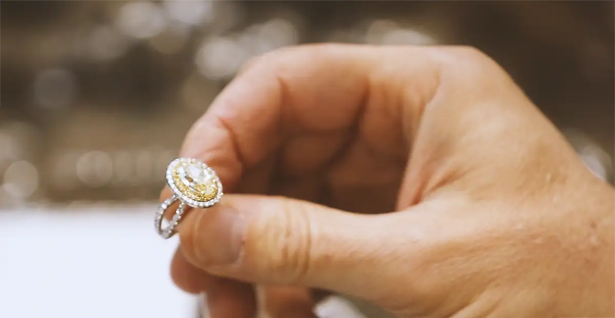 Skilled Chicago jeweler carefully holding a stunning diamond engagement ring, symbolizing precision, craftsmanship, and commitment to creating unforgettable custom jewelry moments.