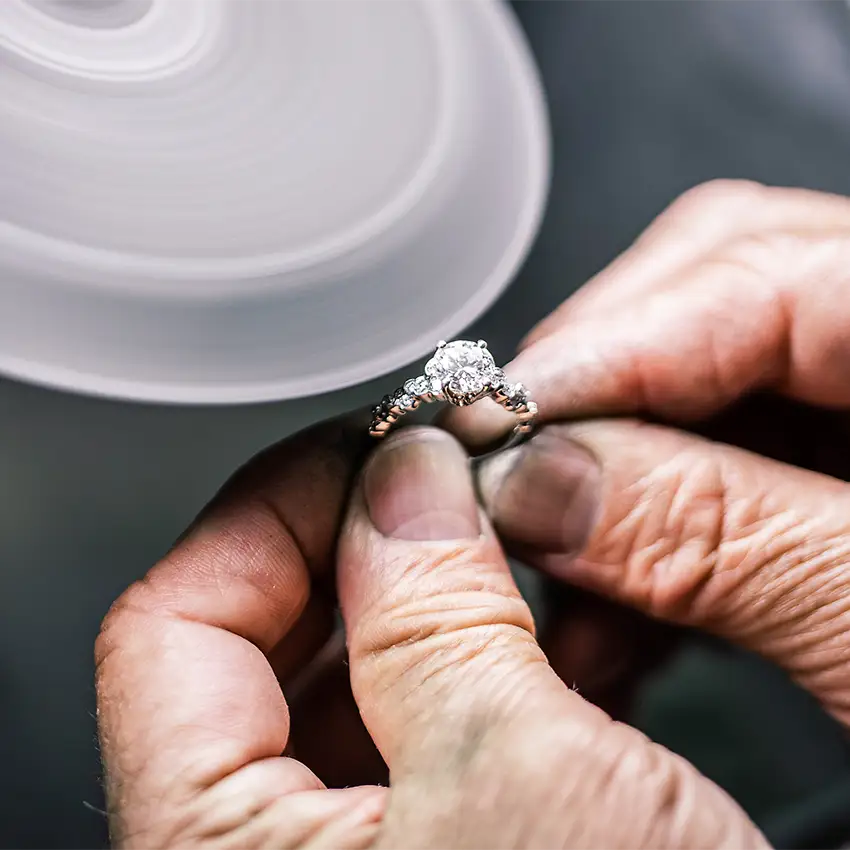 A handcrafted custom diamond engagement ring being polished by our in-house Chicago jeweler.